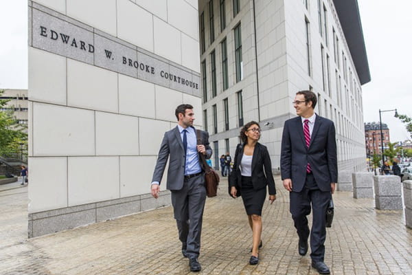 Three people in suits walking outside