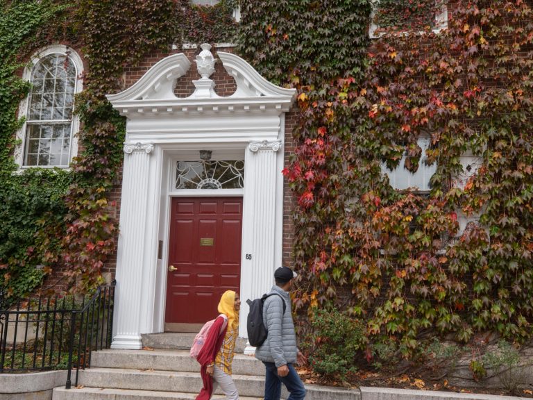Two people walking past Kirkland house.