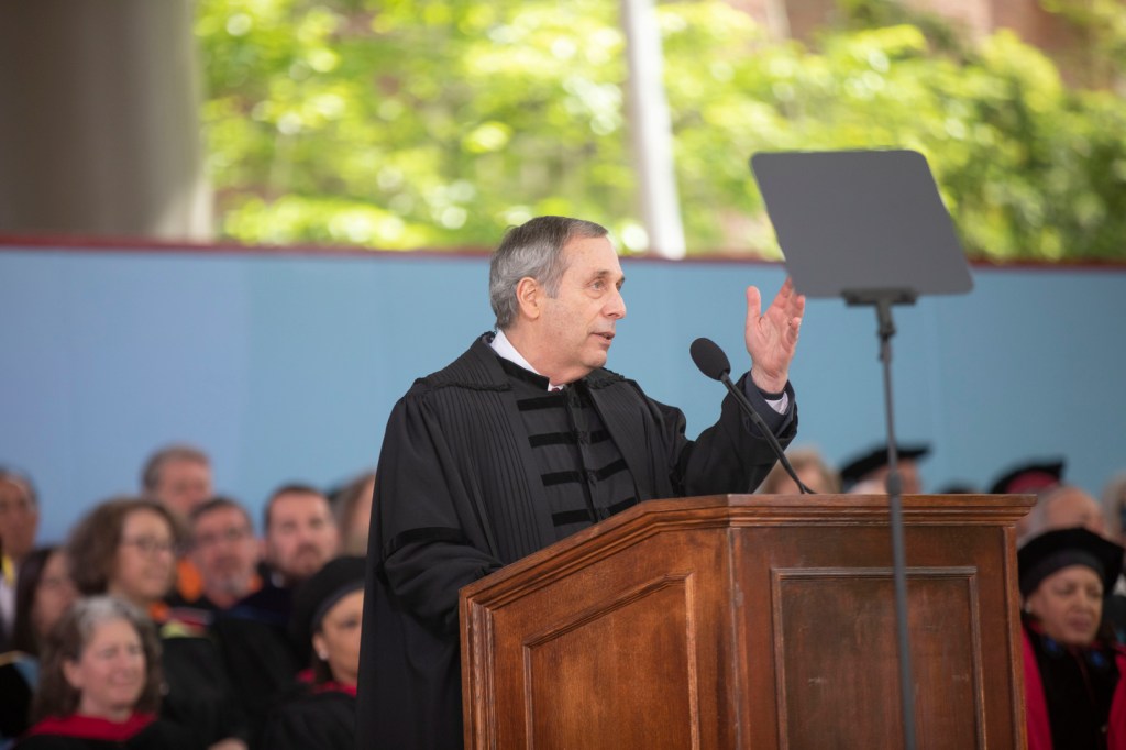 President Larry Bacow at the podium, giving a speech to the Class of 2023.