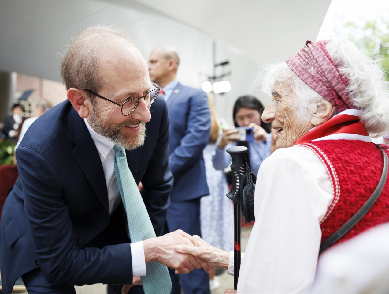 President Garber shakes the hand of an older woman with white hair.