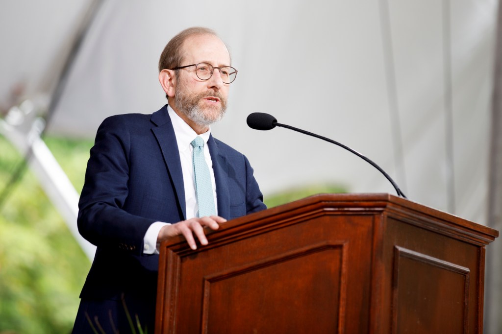 Harvard President Alan Garber talking at a podium
