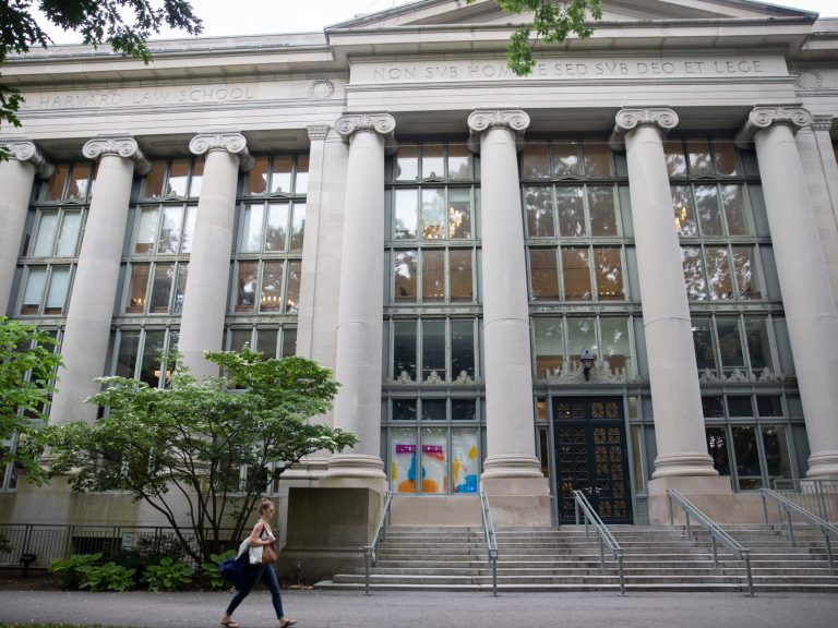 A woman walking by Langdell Library at the Harvard Law School