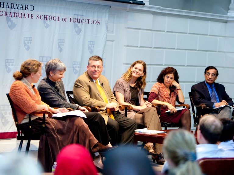 six people sitting on stage talking