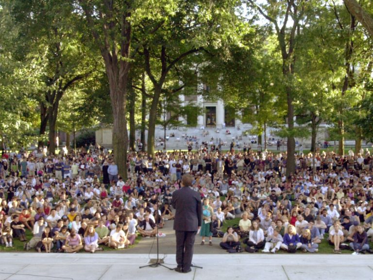 The Harvard president standing in front of a crowd