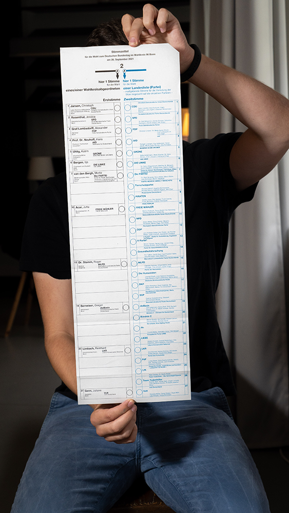 Someone holding a very long voting ballot