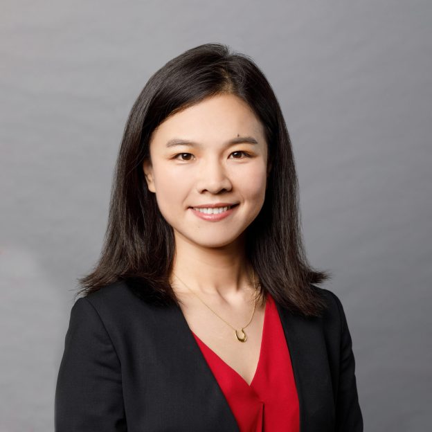 Headshot of a woman in a red top and black blazer