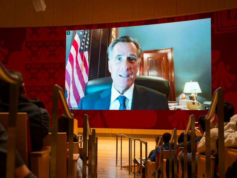 Mitt Romney on a screen in front of an audience