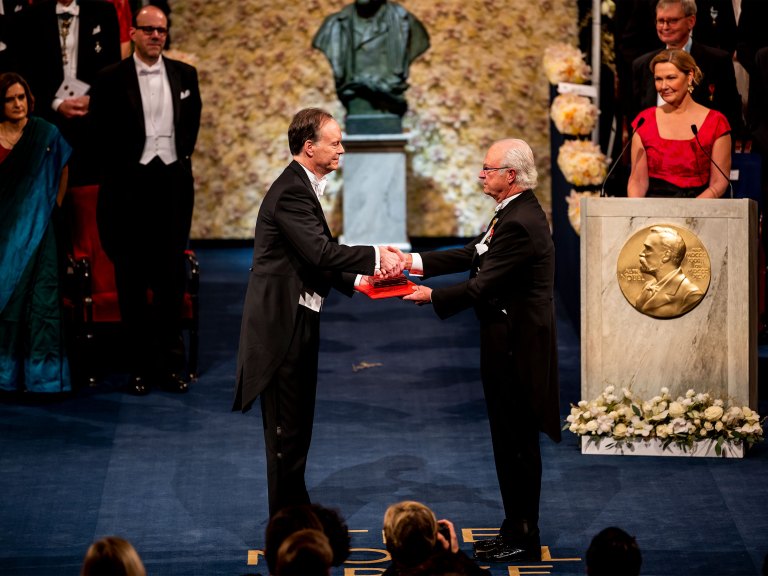 A man receives a Nobel Prize in a ceremony