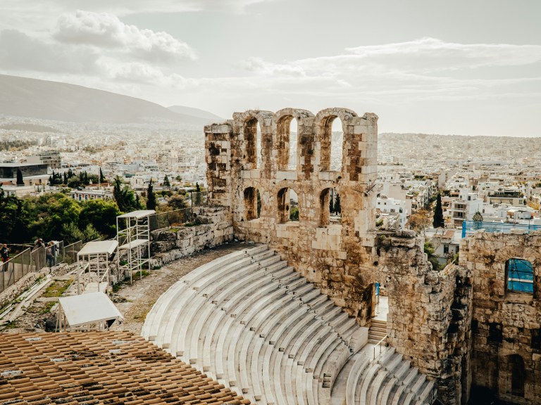 Greece ruins in front of a modern city