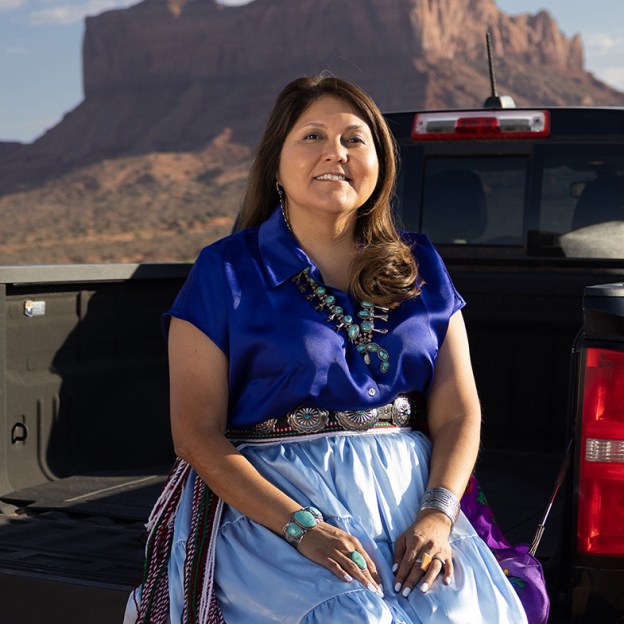 Jaynie Parrish sitting on a truck in the desert