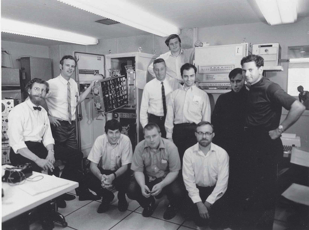 A group of scientists in front of a large computer