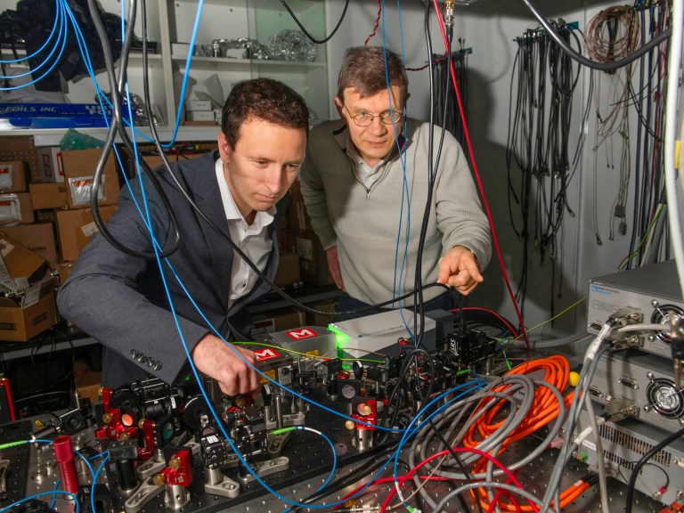 Two researchers working with lasers and wires
