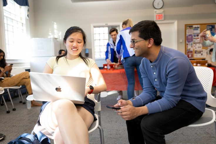 A student and a teacher working on something together